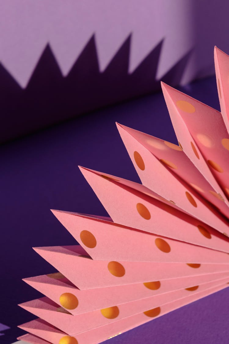 Folded Pink Paper On Purple Background
