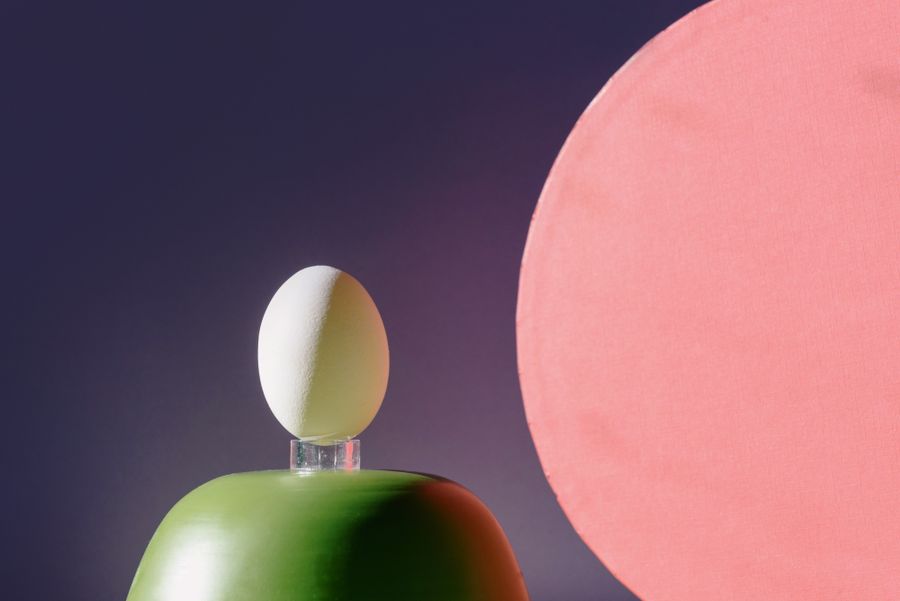 An egg balanced on a painted form against a pink disc — photo by Ksenia Chernaya on Pexels