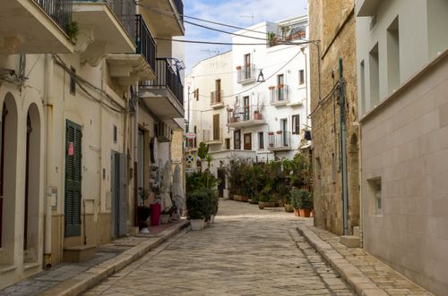 Free Scenic narrow street with Mediterranean architecture in a historic town. Stock Photo