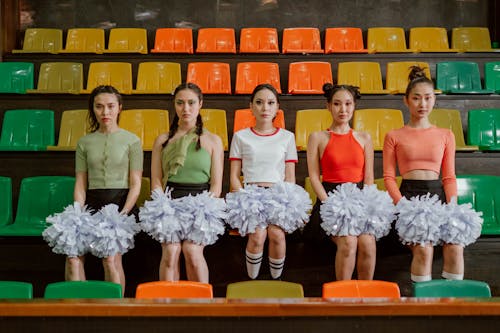 Free Cheerleaders Sitting on Multicolored Bleachers Stock Photo