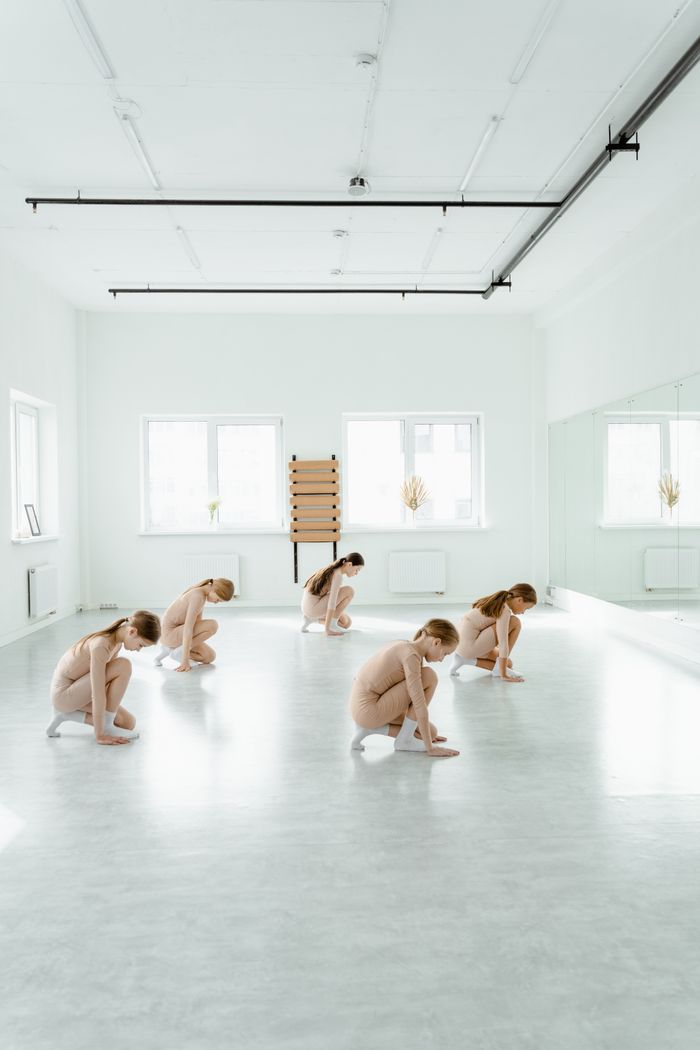 Group of young girls practicing dance together in a bright studio
