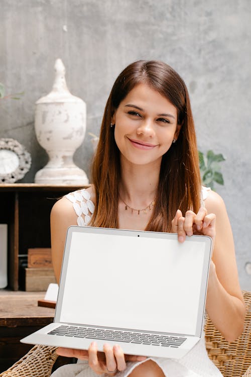 Woman Smiling While Holding a Laptop