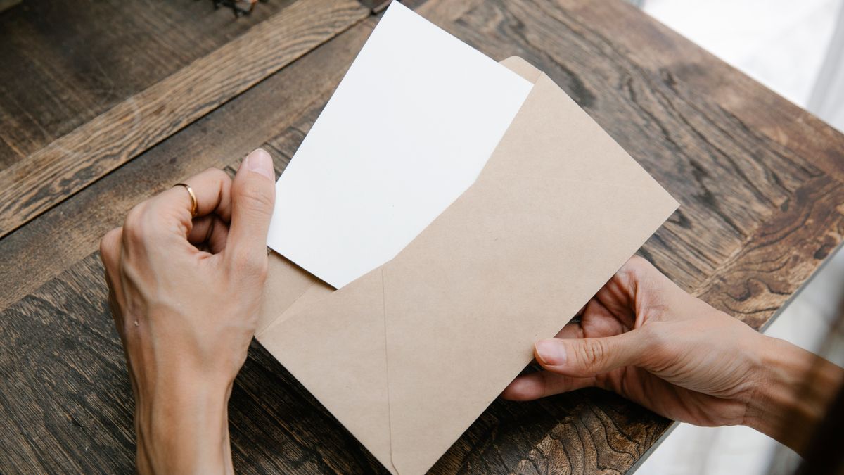 茶封筒から書類を取り出している手元のイメージ