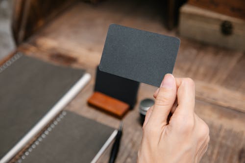 Close Up Photo of Person Holding a Black Card