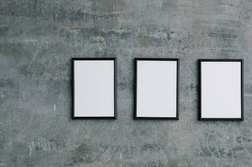Three Empty Picture Frames on a Concrete Wall 
