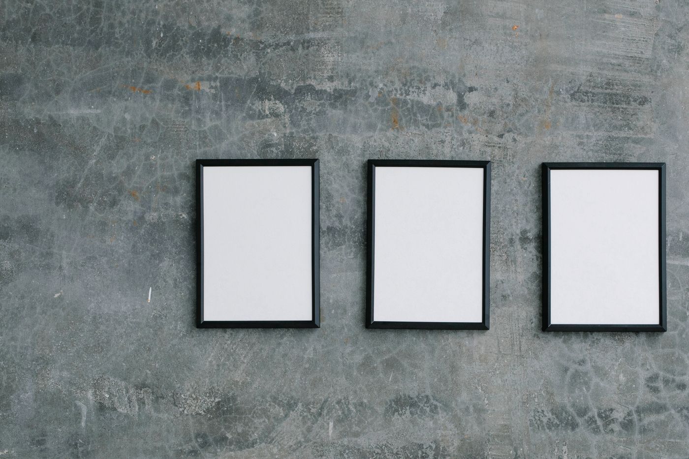 Blank picture frames on a textured concrete wall by Angela Roma on Pexels