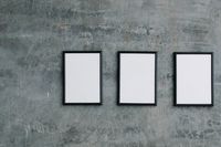 Blank picture frames on a textured concrete wall by Angela Roma on Pexels