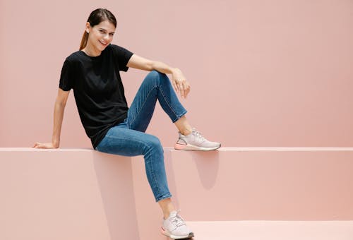 Content model in casual outfit resting on fence outdoors