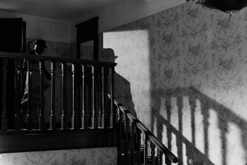 Free A mysterious noir scene with a detective's shadow on a vintage staircase. Stock Photo