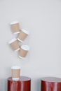 White disposable cups with kraft paper hanging on wall