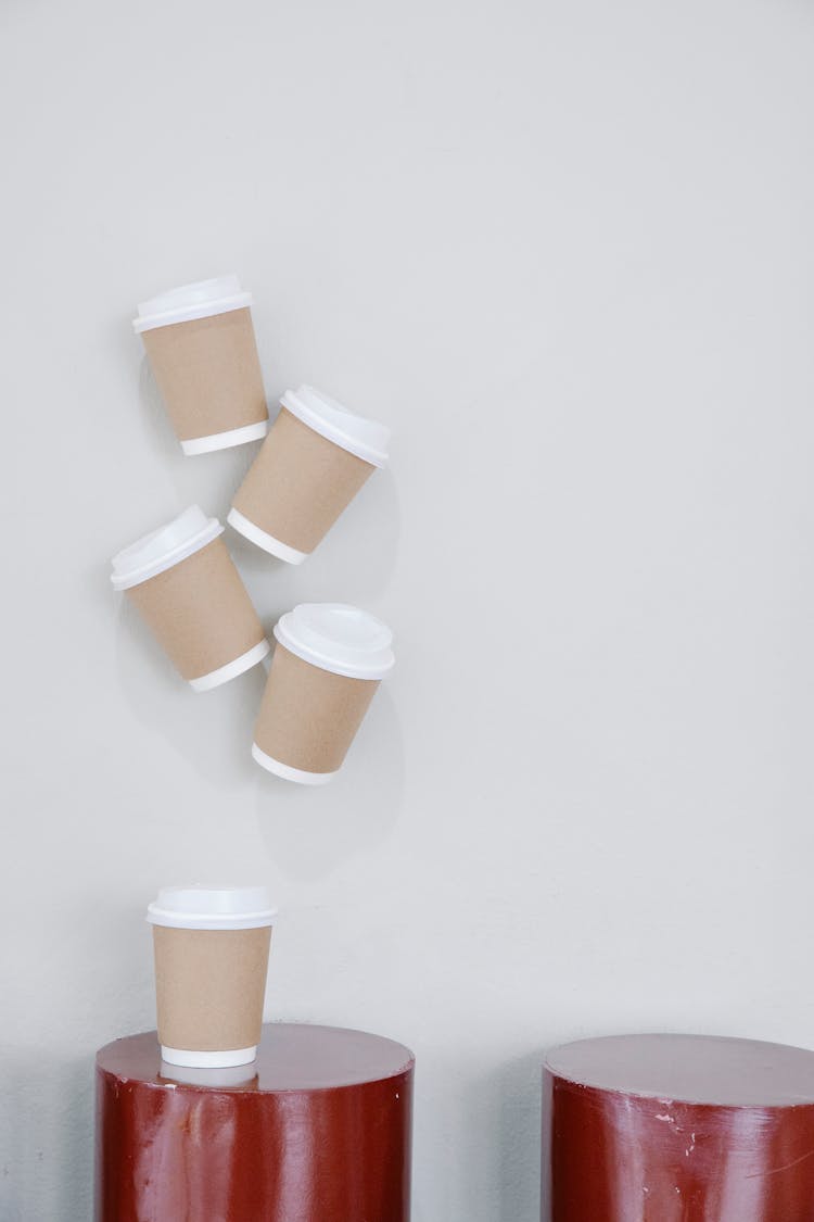 White Disposable Cups With Kraft Paper Hanging On Wall