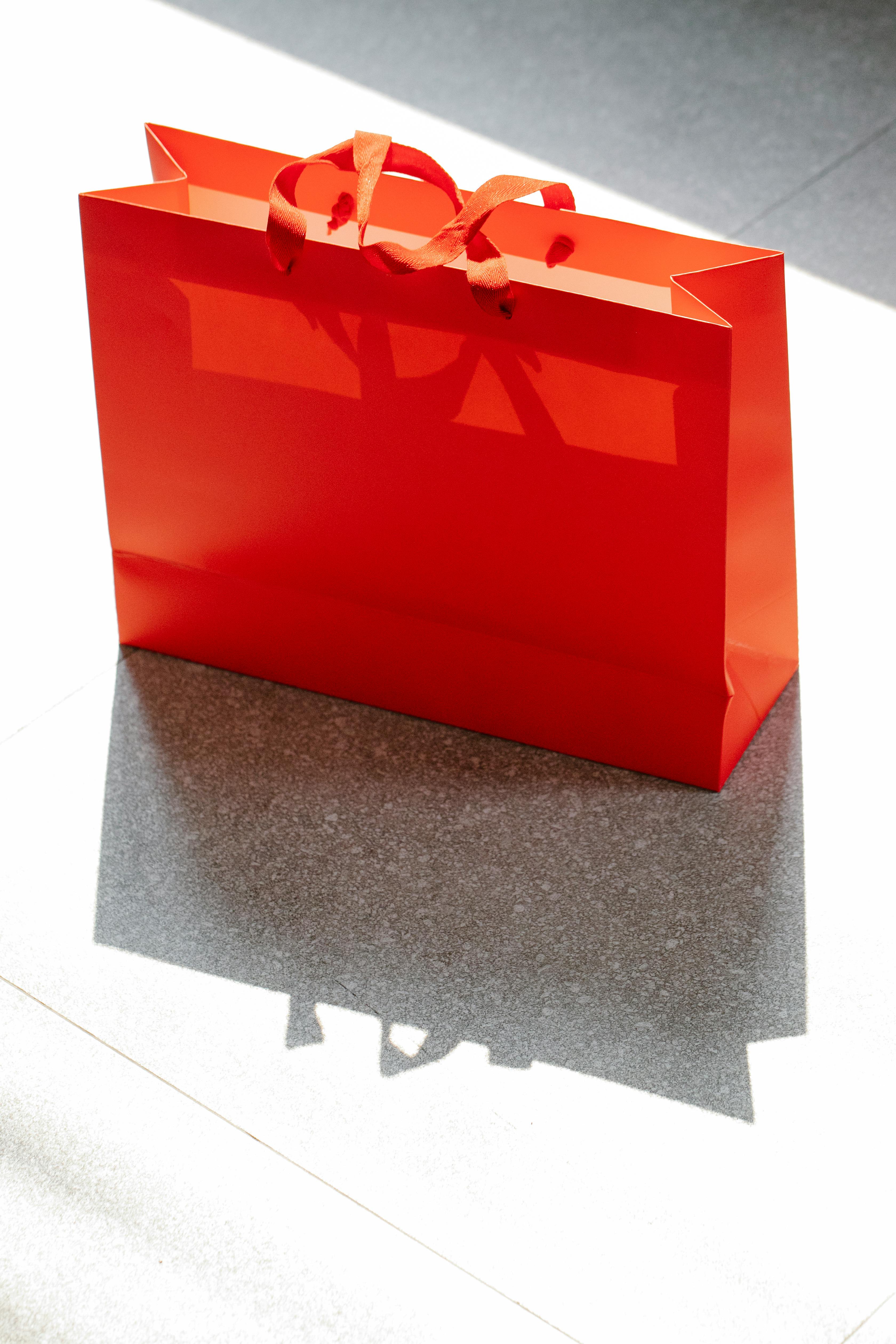 red shopping bag placed on street in daylight