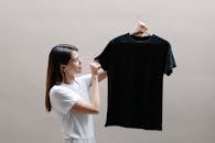 Smiling woman showing t shirt on hanger