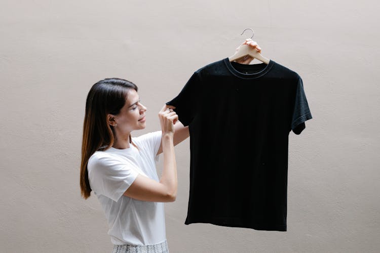 Smiling Woman Showing T Shirt On Hanger