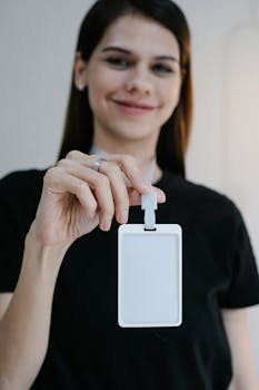 Portrait of a cheerful woman holding a blank ID badge, perfect for business or event promotion.