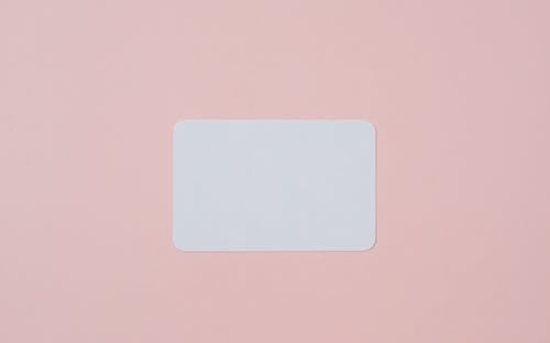Free White visiting card with empty space for data placed on light pink background Stock Photo