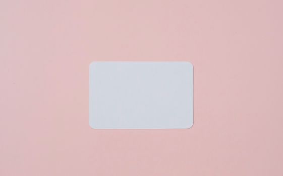 White visiting card with empty space for data placed on light pink background