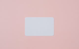 White visiting card with empty space for data placed on light pink background