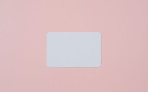 Free White visiting card with empty space for data placed on light pink background Stock Photo