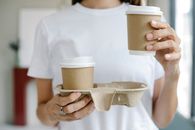 Crop female enjoying takeaway coffee