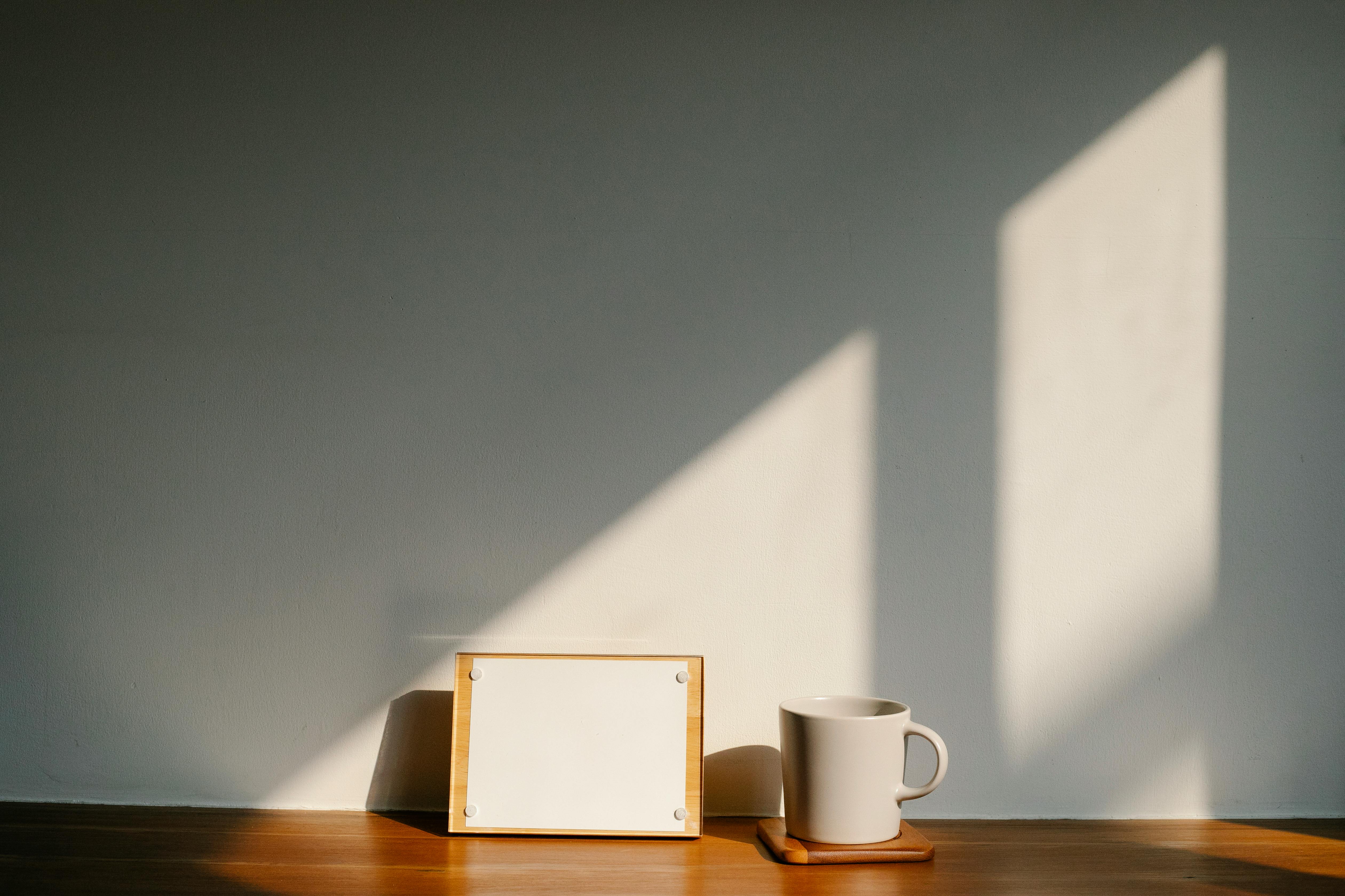 mug near board with blank paper