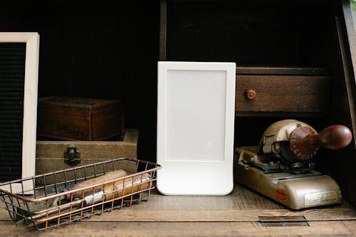 White empty frame on shabby desk near retro stationery