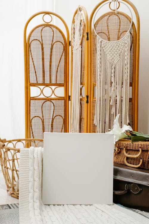 White blank canvas placed against vintage suitcases and classic folding screen in light room