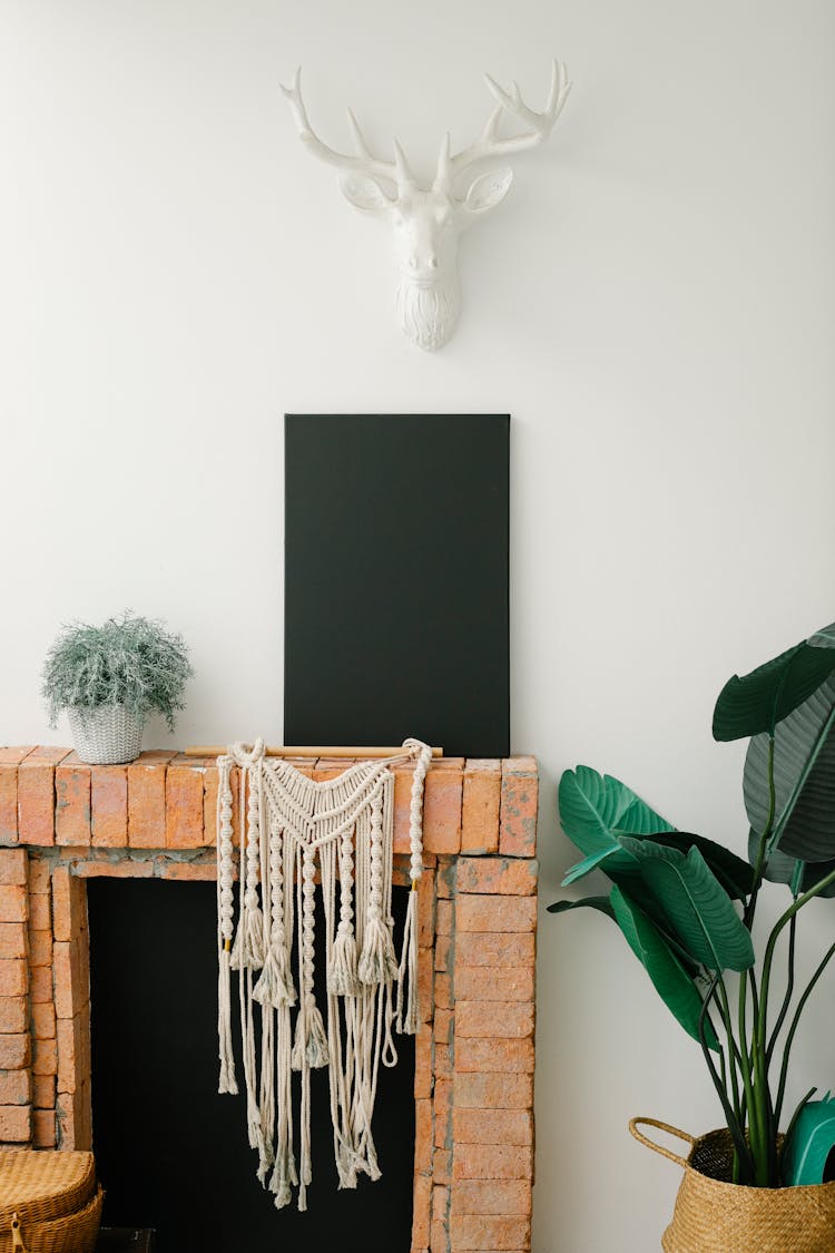 Black Canvas Placed On Brick Fireplace In Light Room