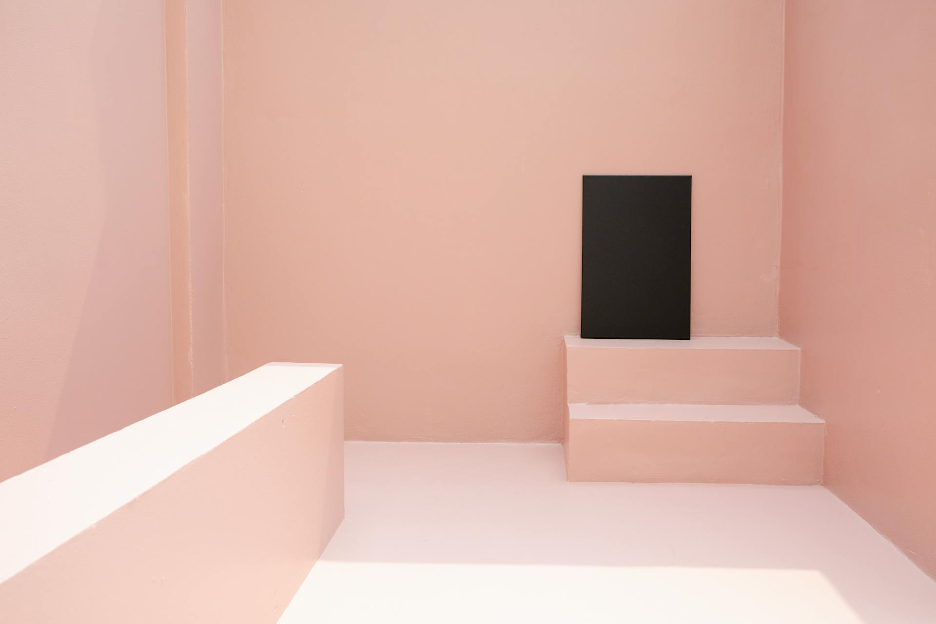 Black canvas placed on staircase in pink room