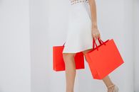 Woman carrying bright red shopping bags