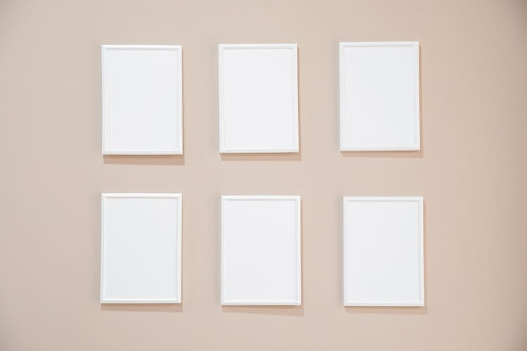 White Empty Frames Hanging On Wall