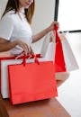 Woman sitting with white and red shopping bags