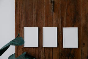 Empty white photo frames on wooden surface