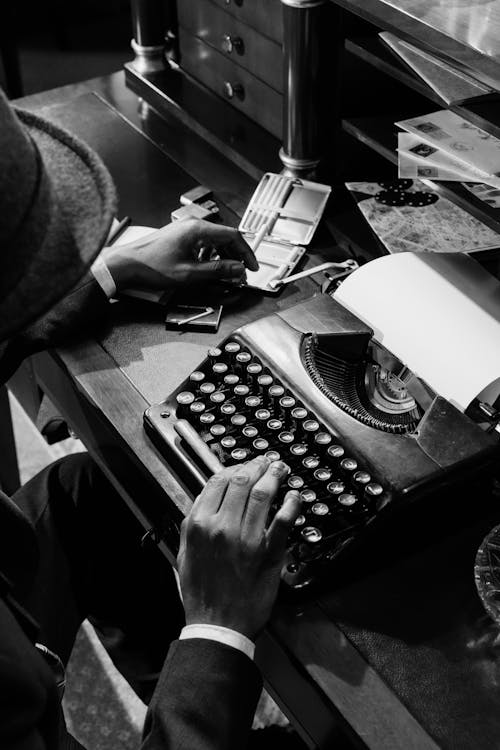Free Monochrome Photo of Person Using Vintage Typewriter Stock Photo