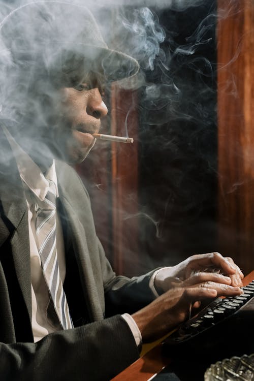 Free Photo of Man Smoking while Working Stock Photo