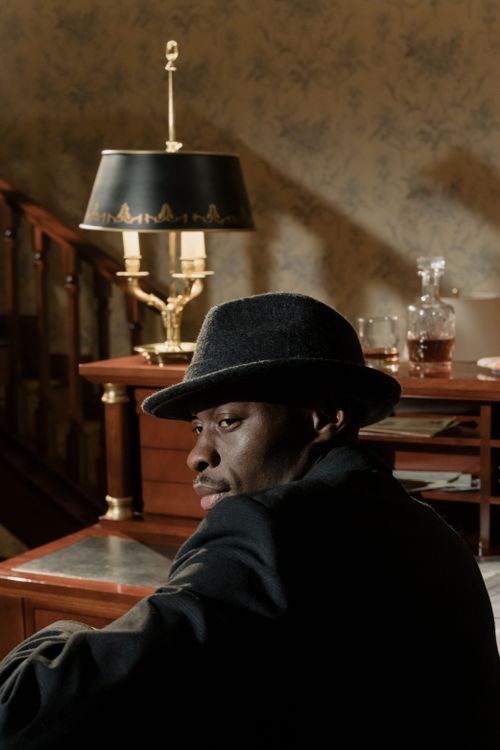 Free A moody scene featuring a black detective in a vintage office setting with classic decor. Stock Photo