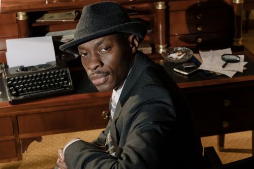 Free A mysterious detective in a 1950s-themed office setting, exuding a noir ambiance. Stock Photo
