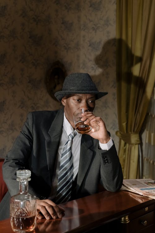 Photo of Man in Black Suit Drinking Whiskey