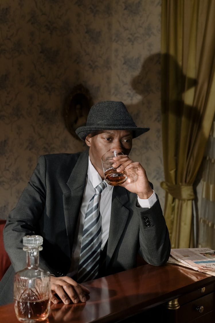 Photo Of Man In Black Suit Drinking Whiskey