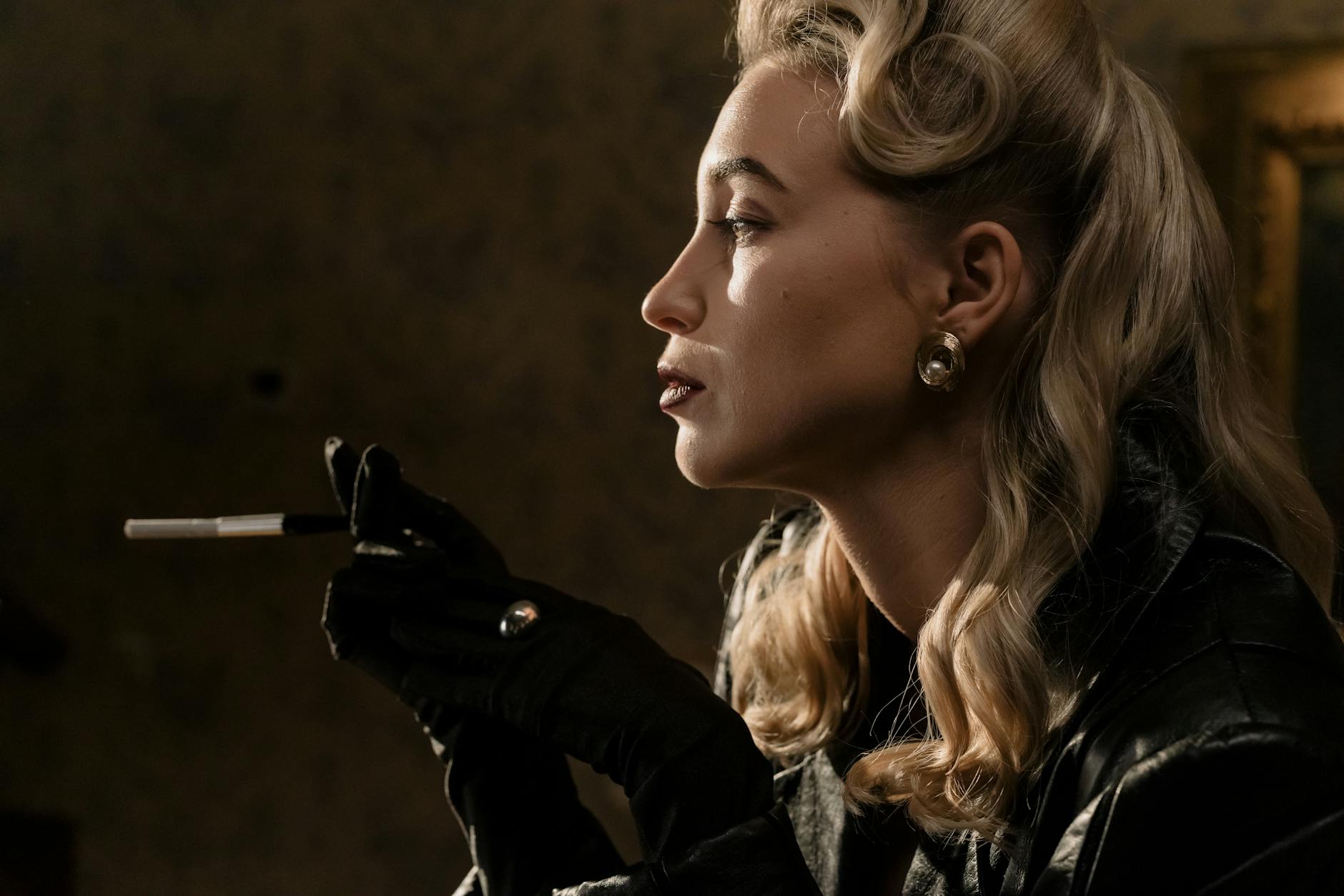 Side View Of Blonde Woman in Black Leather Jacket Holding A Cigarette