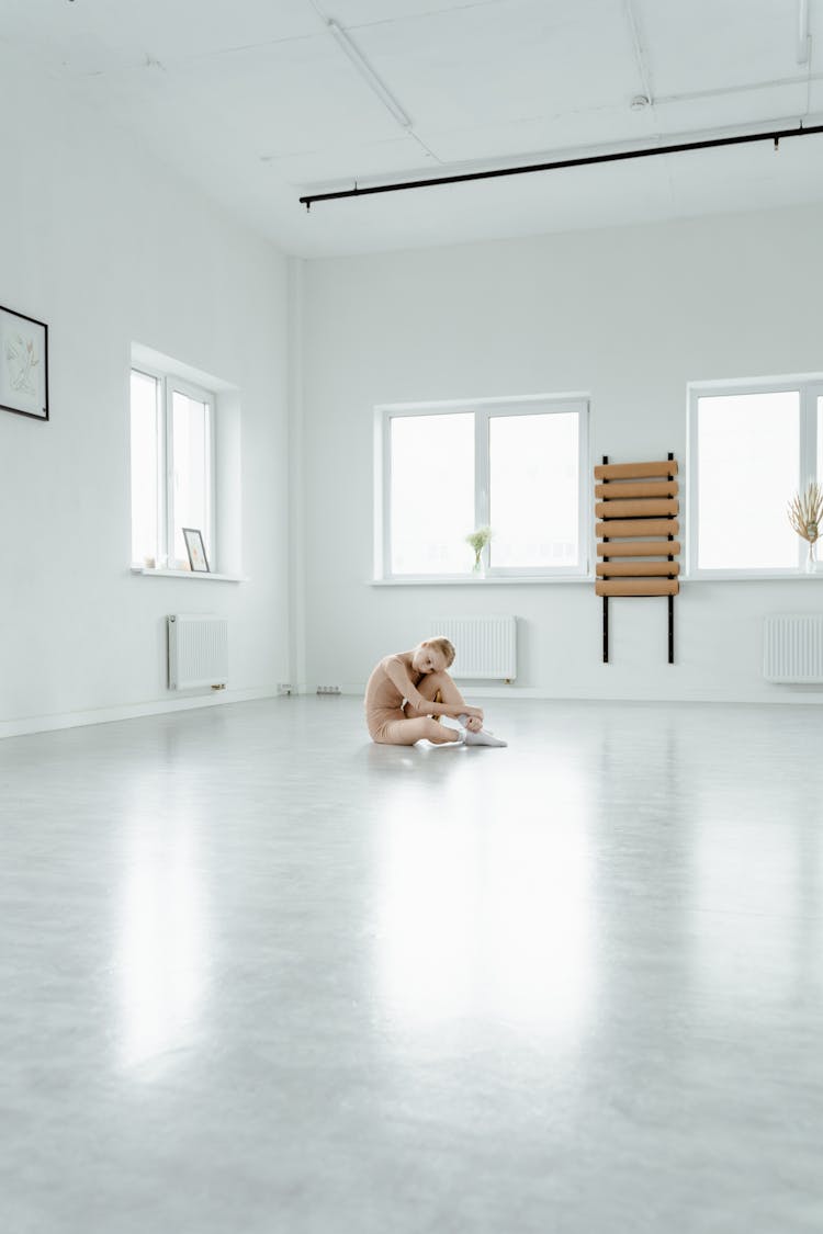 A Girl In Sitting On Floor Resting Her Head On Her Knee