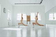 A Pair of Women Doing Some Lunges with Arms Up