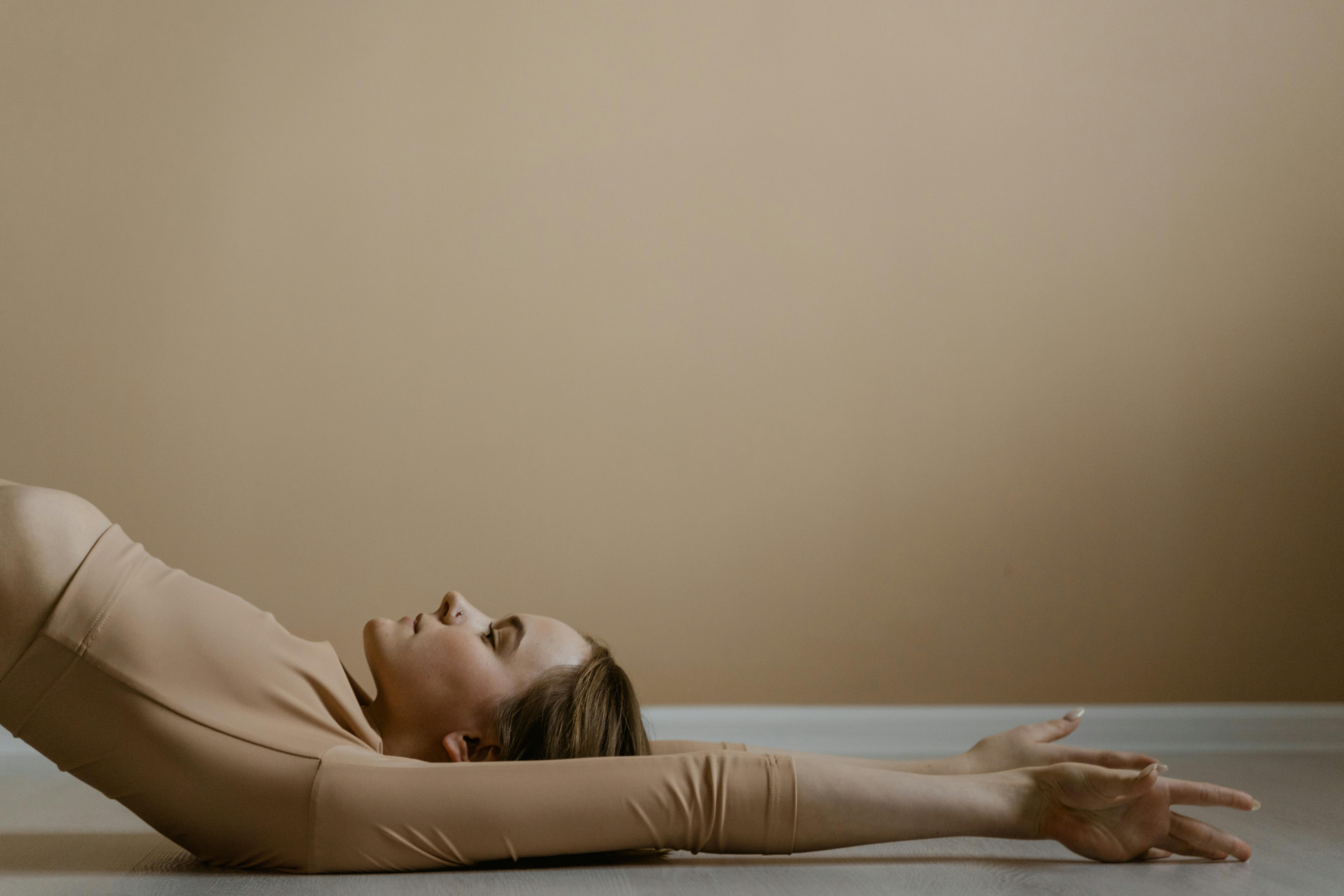 woman in beige long sleeve shirt lying on bed