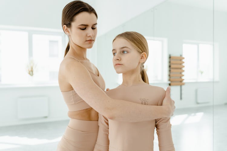 An Instructor Teaching A Girl The Right Posture In Dancing