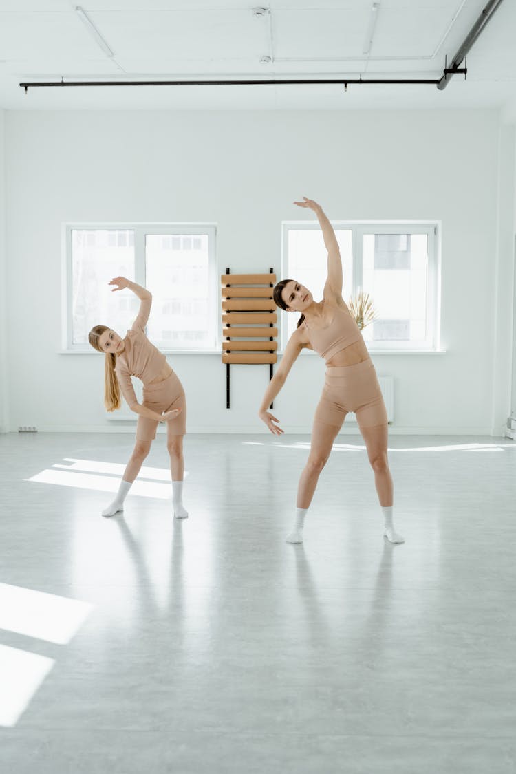 A Girl And A Woman Doing A Sideways Bend