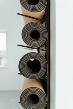 An artistic view of stacked yoga mats in a modern minimalist indoor space.