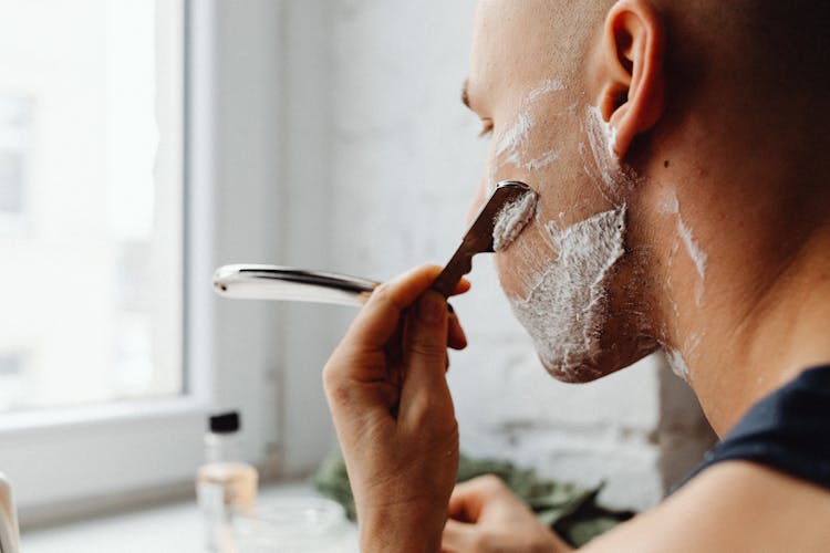 Close-up A Man Shaving His Face 