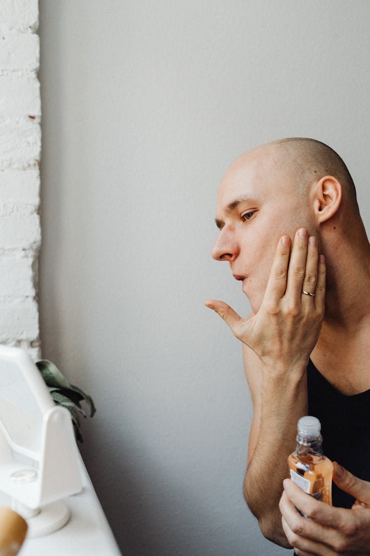 Photo Of A Bald Man Touching His Cheek