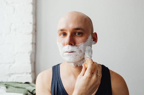 Free Bald Man Applying Shaving Cream on His Face Stock Photo