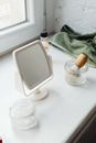 A Mirror Beside Glass Containers and Shaving Brush
